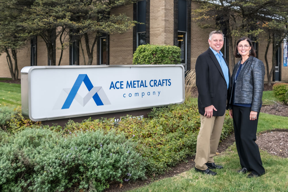 Keith Stout and Jean Pitzo in front of ACE Metal Crafts Company Headquarters